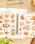 Premium Handmade Sticker Sheet Autumn in my Heart 105mm x 148mm - 2 sheets on the table with a plant branch, an opened notebook