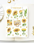 Premium Handmade Sticker Sheet Chamomile Sunflower 105mm x 148mm - a sheet on the table with a white flower branch, an opened notebook