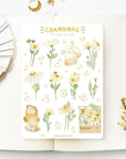 Premium Handmade Sticker Sheet Chamomile Sunflower 105mm x 148mm - a sheet on the table with a white flower branch, an opened notebook
