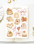 Premium Handmade Sticker Sheet
Chocolate Lover 105mm x 148mm - a sheet on the table with a white flower branch, an opened notebook