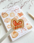Premium Handmade Sticker Sheet
Chocolate Lover 105mm x 148mm - a piece and a sheet on the table with a dark maroon flower branch, a pencil in the background