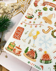 Premium Handmade Sticker Sheet Christmas 105mm x 148mm - a sheet on the table with a white flower branch, an opened notebook, an acorn, a pinecone, a star