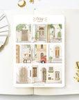 Premium Handmade Sticker Sheet Cozy Doors 105mm x 148mm - a sheet on the table with a white flower branch, an opened notebook