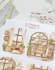 Premium Handmade Sticker Sheet Cozy Hideout 105mm x 148mm - 4 pieces on the table with a pink flower branch