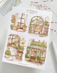 Premium Handmade Sticker Sheet Cozy Hideout 105mm x 148mm - 4 pieces on the table with a pink flower branch