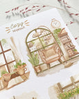 Premium Handmade Sticker Sheet Cozy Hideout 105mm x 148mm - 4 pieces on the table with a pink flower branch