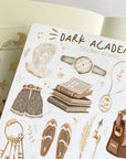 Premium Handmade Sticker Sheet Dark & Light Academia 105mm x 148mm - a sheet on the table with an opened notebook