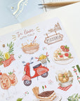 Premium Handmade Sticker Sheet In Love With Italy 105mm x 148mm - a sheet on the table with an opened notebook, a pencil