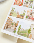 Premium Handmade Sticker Sheet Inspired by Italy 105mm x 148mm - a sheet on the table with an opened notebook