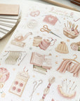 Premium Handmade Sticker Sheet Knitting Crochet 105mm x 148mm - a sheet on the table with a pencil, an opened notebook, a ruler