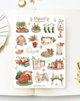 Premium Handmade Sticker Sheet Magical Cozy Winter 105mm x 148mm - a sheet on the table with a white flower branch, an opened notebook
