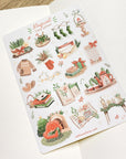 Premium Handmade Sticker Sheet Magical Cozy Winter 105mm x 148mm - a sheet on the table with an opened notebook