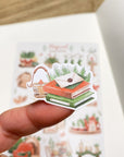 Premium Handmade Sticker Sheet Magical Cozy Winter 105mm x 148mm - a piece and a sheet on the table with an opened notebook