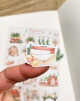 Premium Handmade Sticker Sheet Magical Cozy Winter 105mm x 148mm - a piece and a sheet on the table with an opened notebook