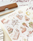 Premium Handmade Sticker Sheet Reading at Home 105mm x 148mm - a sheet on the table with a dark maroon flower branch, an opened notebook, a pencil, a ruler
