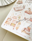 Premium Handmade Sticker Sheet Reading at Home 105mm x 148mm - a sheet on the table with an opened notebook
