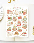 "Premium Handmade Sticker Sheet
Reading in the Winter 105mm x 148mm - a sheet on the table with a white flower branch, an opened notebook"