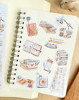 Premium Handmade Sticker Sheet Reading Time 105mm x 148mm - a sheet and 11 pieces on the table with a white flower branch, an opened notebook