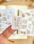 Premium Handmade Sticker Sheet Reading Time 105mm x 148mm - a piece and 2 sheets on the table with an opened notebook in the background