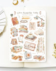 Premium Handmade Sticker Sheet Reading Time 105mm x 148mm - a sheet on the table with a white flower branch, an opened notebook