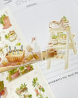 Premium Handmade Sticker Sheet
Veggie Garden 105mm x 148mm - 2 pieces and a sheet on the table with an opened notebook