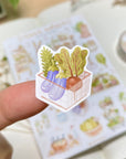 Premium Handmade Sticker Sheet
Veggie Garden 105mm x 148mm - a piece and a sheet on the table with a white flower branch, an opened notebook, a washi tape