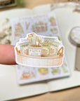 Premium Handmade Sticker Sheet
Veggie Garden 105mm x 148mm - a piece and a sheet on the table with a white flower branch, an opened notebook, a washi tape in the background