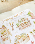Premium Handmade Sticker Sheet
Veggie Garden 105mm x 148mm - a sheet on the table with a white flower branch, an opened notebook