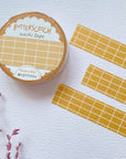 Premium Handmade Washi Tape Butterscotch Grid 15mm x 10m - 3 pieces and a washi tape on the table with a dark maroon flower branch