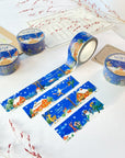 Premium Handmade Washi Tape Cozy Winter 20mm x 10m - 4 pieces and 4 washi tapes on the table with 2 dark maroon flower branches, a sticker sheet, a chapter heading, a notebook