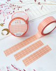 Premium Handmade Washi Tape Peach Grid 15mm x 10m - 3 pieces and 3 washi tapes on the table with 2 dark pink flower branches, a chapter heading, a sticker sheet