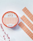 Premium Handmade Washi Tape Peach Grid 15mm x 10m - 3 pieces and a washi tape on the table with
a dark pink flower branch