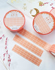 Premium Handmade Washi Tape Peach Grid 15mm x 10m - 3 pieces and 4 washi tapes on the table with
a dark pink flower branch, a sticker sheet