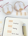 Premium Handmade Washi Tape Time Planner 15mm x 10m - a piece and 2 washi tapes on the table with 2 pink flower branches, a notebook, a pen