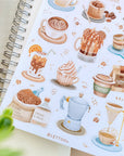 Premium Handmade Sticker Sheet Coffee 105mm x 148mm - a sheet on the table with a plant branch, an opened notebook