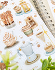 Premium Handmade Sticker Sheet Coffee 105mm x 148mm - a sheet on the table with a plant branch, an opened notebook