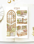 Premium Handmade Sticker Sheet Cozy Corner 105mm x 148mm - a sheet on the table with a white flower branch, an opened notebook