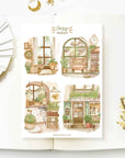 Premium Handmade Sticker Sheet Cozy Hideout 105mm x 148mm - 4 pieces on the table with a white flower branch, an opened notebook