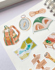 Premium Handmade Sticker Sheet Into The Wild 105mm x 148mm - 9 pieces on the hand note on the table