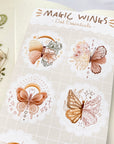 Premium Handmade Sticker Sheet Magic Wings 105mm x 148mm - a sheet on the table with a white flower branch, an opened notebook