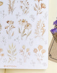 Premium Handmade Sticker Sheet Mellow Flower 105mm x 148mm - a sheet on the table with a purple flower branch, an opened notebook