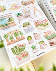 Premium Handmade Sticker Sheet Spring Garden 105mm x 148mm - 2 sheets on the table with an opened notebook, some leaves