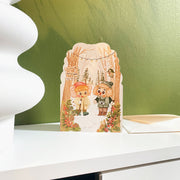 Walking in the Woods Christmas card, styled on a shelf with its envelope