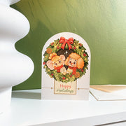 Holiday Wreath Christmas card, English front, styled on a shelf with its envelope