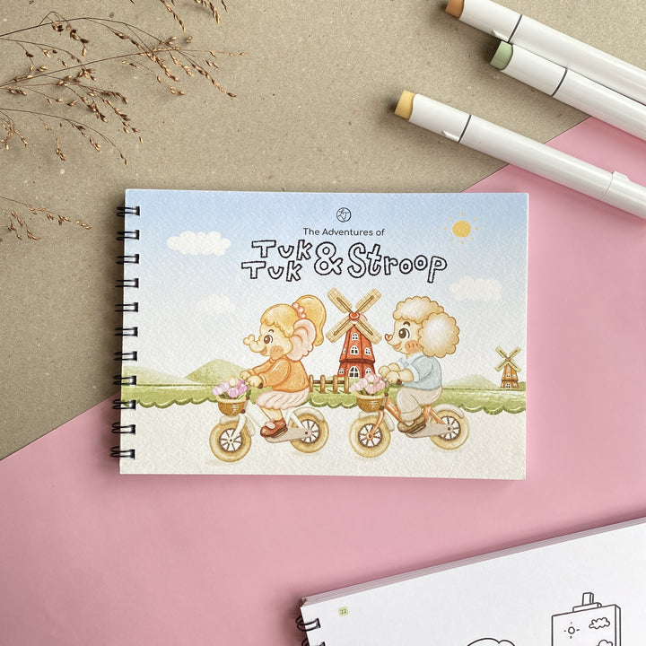 The Adventures of Tuk Tuk & Stroop colouring book, front cover flat lay with markers