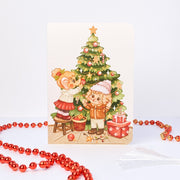 Decorating Tree Christmas card without text: Tuk Tuk the elephant hangs baubles while Stroop the dog holds the lights