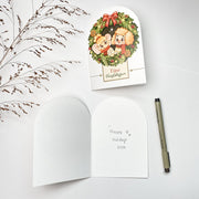 Holiday Wreath Christmas card opened, Dutch front with the blank inside and a pen