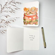Hot Cacao Christmas card opened, with the blank inside and a pen