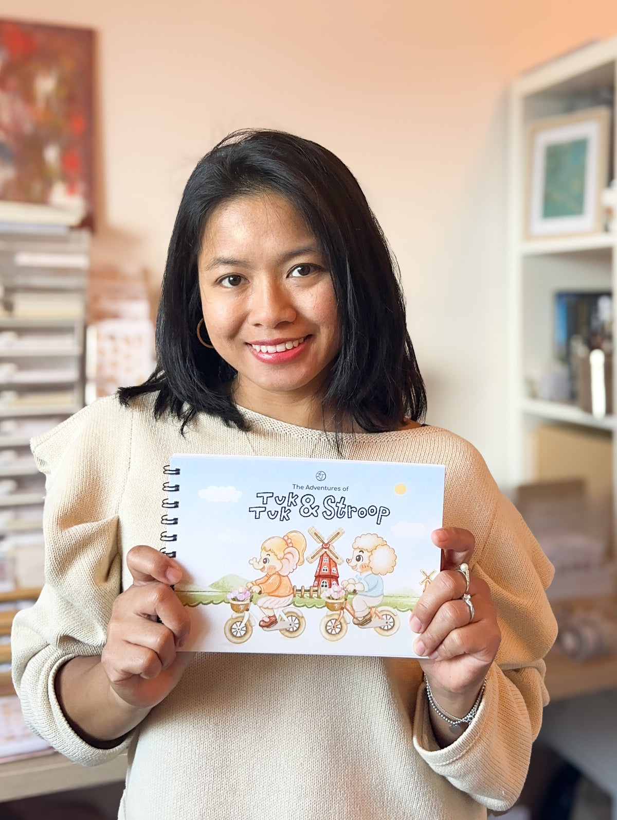 Pongkan holding The Adventures of Tuk Tuk & Stroop colouring book in the Lettoon studio