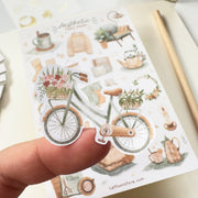 Premium Handmade Sticker Sheet 
Aesthetic Cozy 105mm x 148mm - a piece on the finger and a sheet on the table with a pencil, an opened notebook